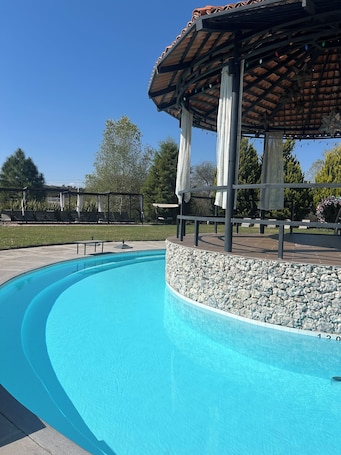 Una piscina al aire libre, sillones reclinables de piscina. Pedernal Hotel