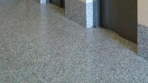 Ein Korridor mit zwei Aufzügen, einer Treppe und einem Schild, das die Etage angibt.