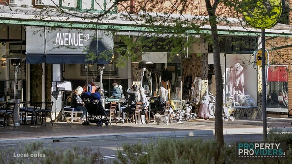 Ein Schaufenster mit einem Schild mit der Aufschrift "AVENUE RD" und verschiedenen Artikeln, darunter Kleidung und Accessoires, ausgestellt.