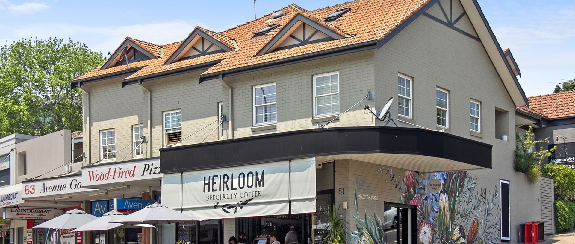 A building with a cafe named 'Heirloom' and a pizza place 'Wood-Fired Pizza'.