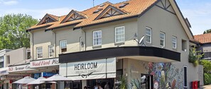 Un immeuble qui abrite un café appelé « Heirloom » et une pizzeria nommée « Wood-Fired Pizza ».