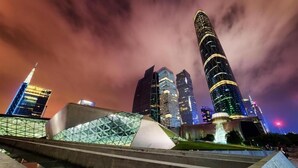 A modern cityscape with illuminated skyscrapers and a distinctive building with a unique roof structure. - City Comfort Inn Guangzhou Tiyu West Road Metro Station (Guangzhou)