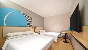 A hotel room with two beds, a desk, a chair, a flat-screen TV, and a wall with a blue and checkered design. - City Comfort Inn Guangzhou Tiyu West Road Metro Station (Guangzhou)