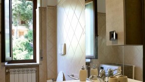 Une salle de bain moderne avec une grande fenêtre, des toilettes, un lavabo et un miroir.