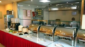 A buffet setup with a red tablecloth, stainless steel chafing dishes, and a glass partition. - Greentree Inn Beijing Changping Shahe Metro Station Express Hotel (Changping)