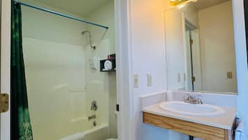 Un baño con ducha, inodoro y lavamanos.