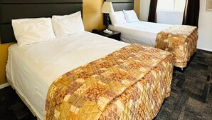 A hotel room with two beds, a headboard, a nightstand, a lamp, and a window with curtains. - Americas Best Value Inn Salmon (Salmon)