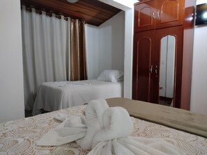 Un dormitorio con una cama, un armario de madera y un espejo.