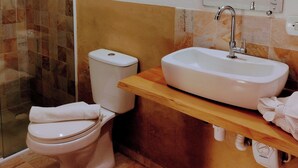 A bathroom with a toilet, a sink, and a shower. - Casa do Papai Pousada (Campos do Jordão)