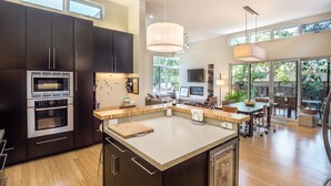 A modern kitchen with dark cabinetry, stainless steel appliances, and a central island.