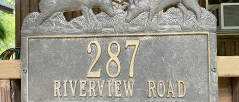 Une plaque de numéro de maison avec deux figurines de cerfs au-dessus du numéro 287 et l’inscription « Riverview Road ».