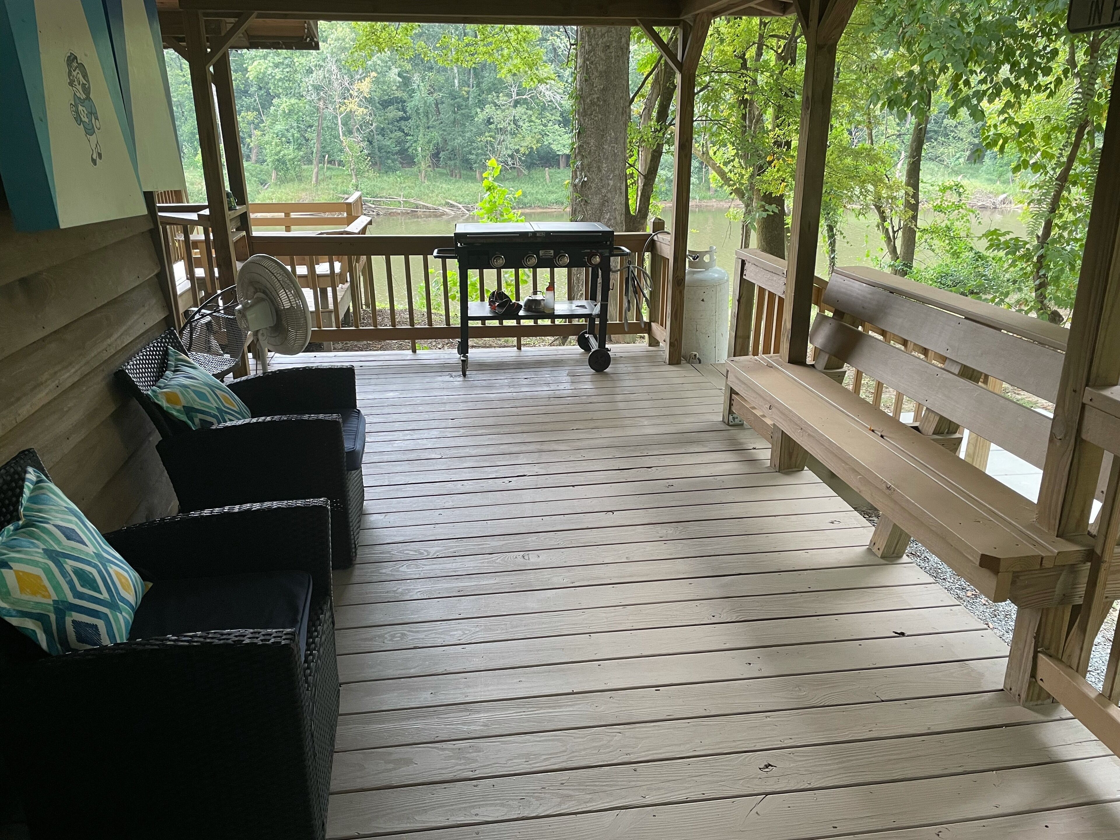 Une terrasse en bois avec un banc et une table, offrant une vue sur un paysage naturel.