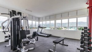 A gym with cardio machines, weightlifting equipment, and a bench. - The Brompton's @ Home (Kingston)
