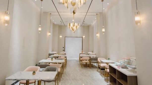 A modern hotel room with a long corridor, multiple seating areas, and a central chandelier. - Greentree Inn (Nanjing)
