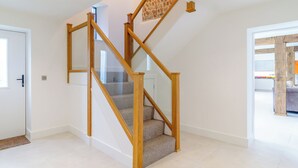 Una escalera moderna con barandas de madera y un suelo estampado.