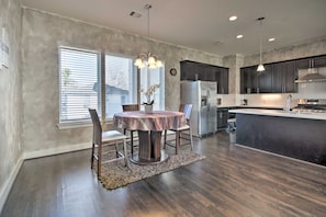 A modern kitchen with dark cabinets, stainless steel appliances, and a central island.