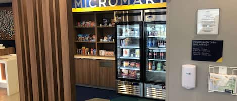 A Micromart store with refrigerated display cases and shelves stocked with snacks and beverages.