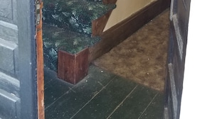 A staircase with wooden balusters and a carpeted landing. - The Keuka at Red Brick Manor (Seneca Falls)