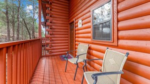 A wooden cabin with a porch, two wicker chairs, and a window. - Walk-In 2BR Grand Mountain Cabin with Ozark Views | Sleeps 6 (Branson)