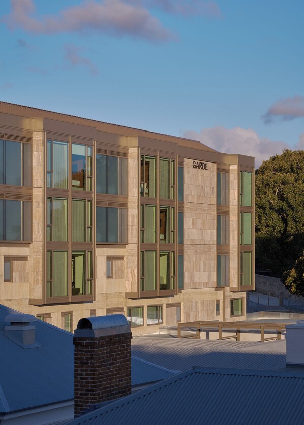 A modern building with large windows and a sign reading "GARDE".