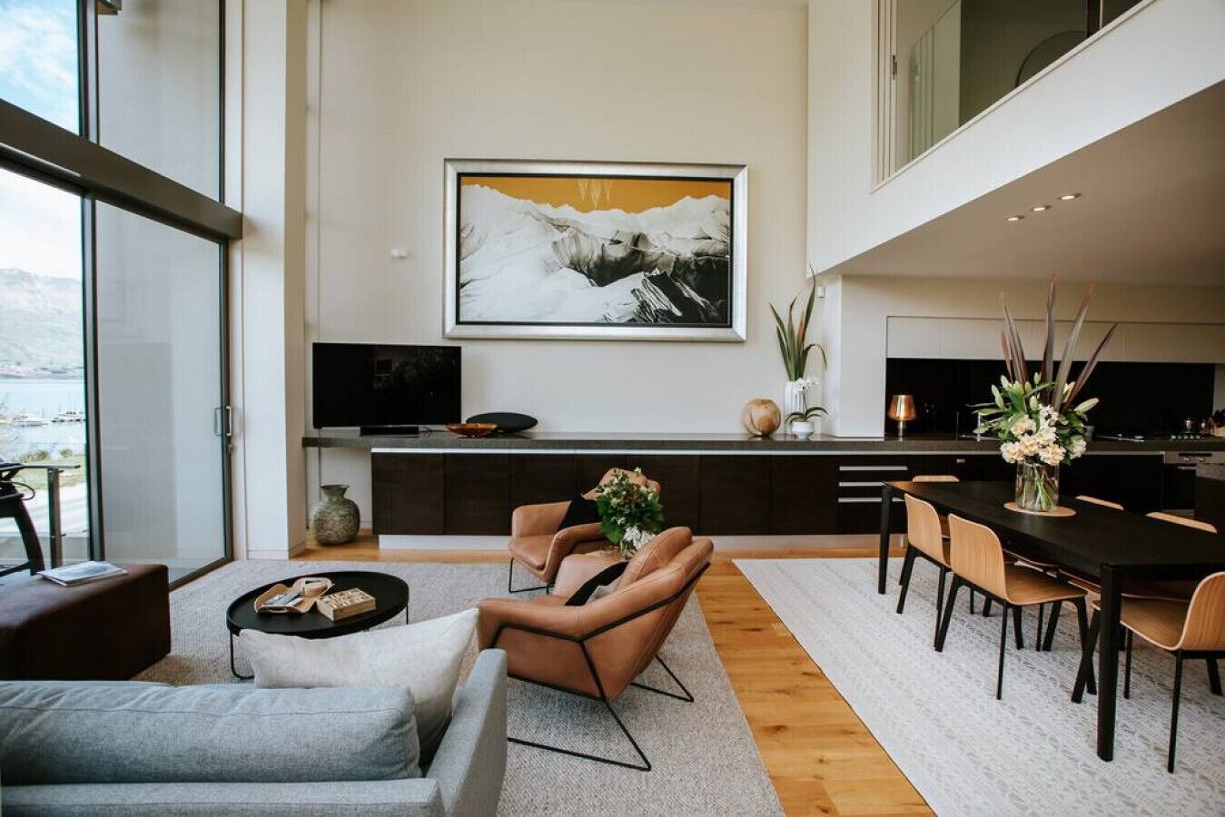 Ein modernes Wohnzimmer mit einer Couch, einem Couchtisch und einem Essbereich mit Stühlen und einem Tisch.