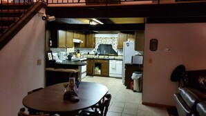 A compact kitchen with wooden cabinets, a dining table, and a built-in oven. - House located in the heart of the Poconos and convenient to all!!!! (Pocono Pines)