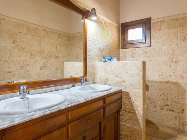 A bathroom with two sinks, wooden vanity, marble countertop, and a large mirror. - Villa Lagoon. Lovely stone built Mallorcan finca with private pool. (Sa Pobla)