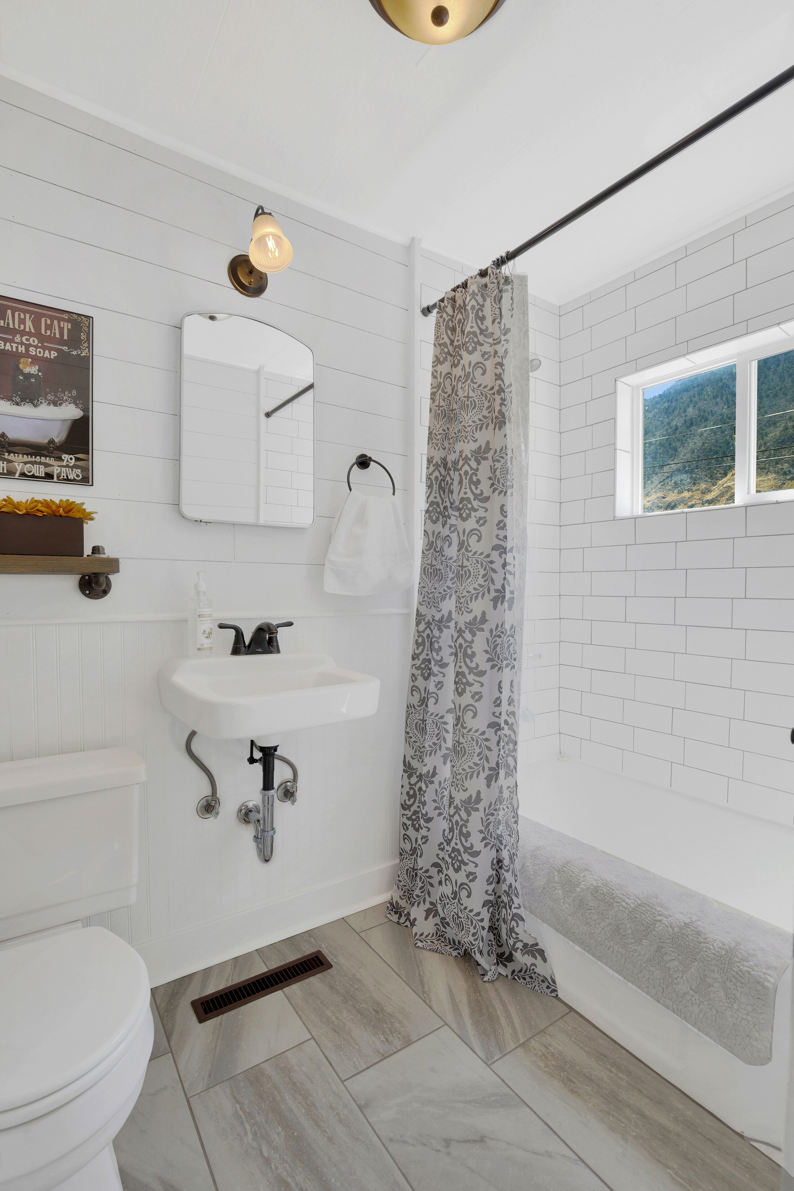 Een bad/douchecombinatie, een haardroger, handdoeken, zeep