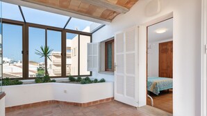 A room with a large window, a bed with a patterned bedspread, and a wooden door. - ESTREL - Wonderful chalet, with private pool and beautiful terraces, 280 meters fromthe be (Muro)