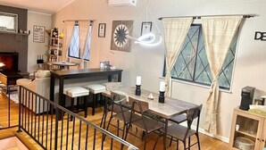 Un soggiorno moderno con zona pranzo, camino e scala.