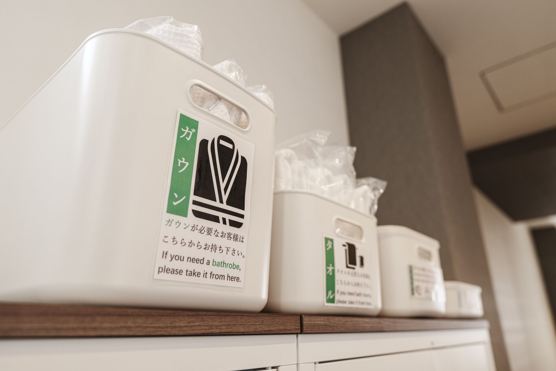 A row of white dispensers with Japanese text and a black symbol, likely for toiletries.