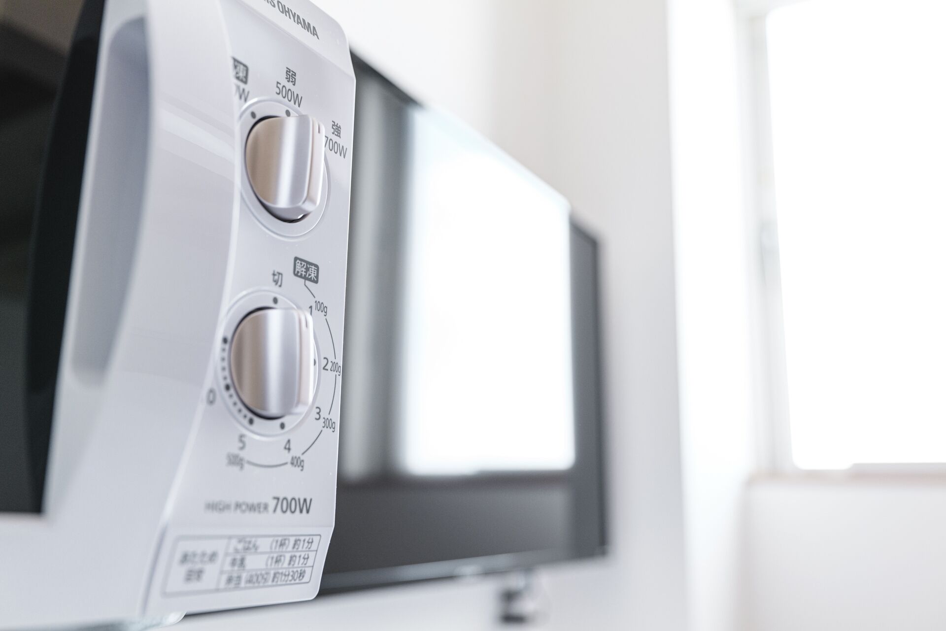 A microwave with a digital display and multiple control knobs.