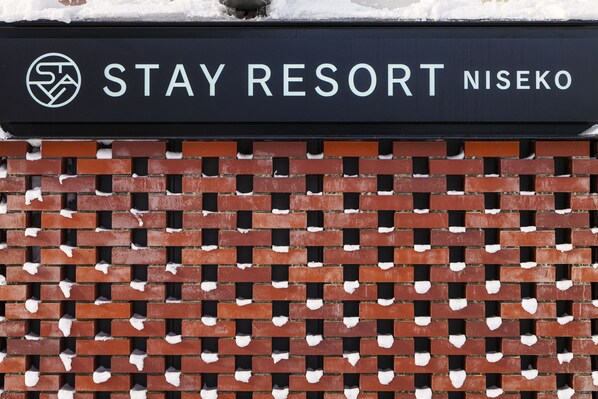 A brick wall with a sign that reads "STAY RESORT NISEKO".