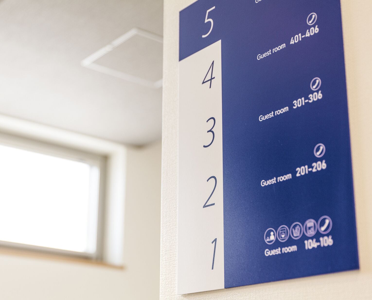 A hotel room number sign with numbers 1 to 5 and corresponding guest room numbers 104-106, 201-206, 301-306, 401-406, and 402-406.