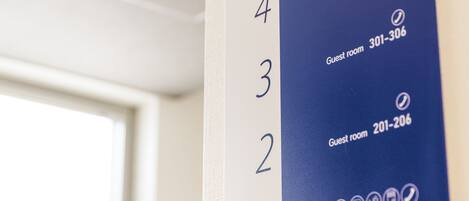A hotel room number sign with numbers 1 to 5 and corresponding guest room numbers 104-106, 201-206, 301-306, 401-406, and 402-406.