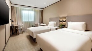 A hotel room with two beds, a desk, a chair, and a TV. - Hanting Hotel (Guangzhou Feixiang Park Metro Station) (Guangzhou)