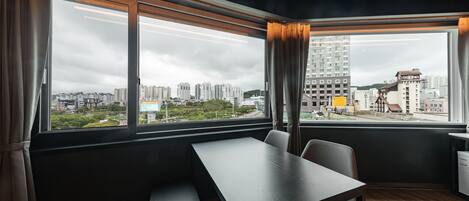 A modern room with a large window, a wooden table, and a bench.