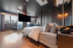 A modern hotel room with a large bed, a desk, a flat-screen TV, and a city view. - Seosan Browndot Hotel (Seosan)