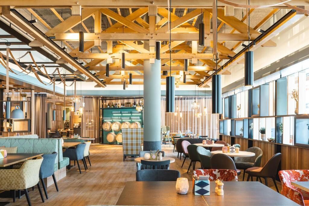 Ein Restaurant mit Holzbalken, Tischen, Stühlen und einer Bar.