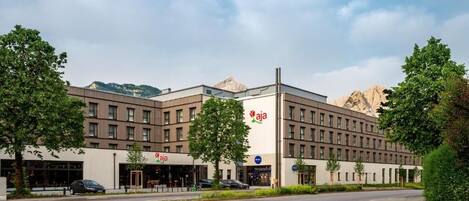 A modern hotel with a flat roof, multiple windows, and a prominent logo.