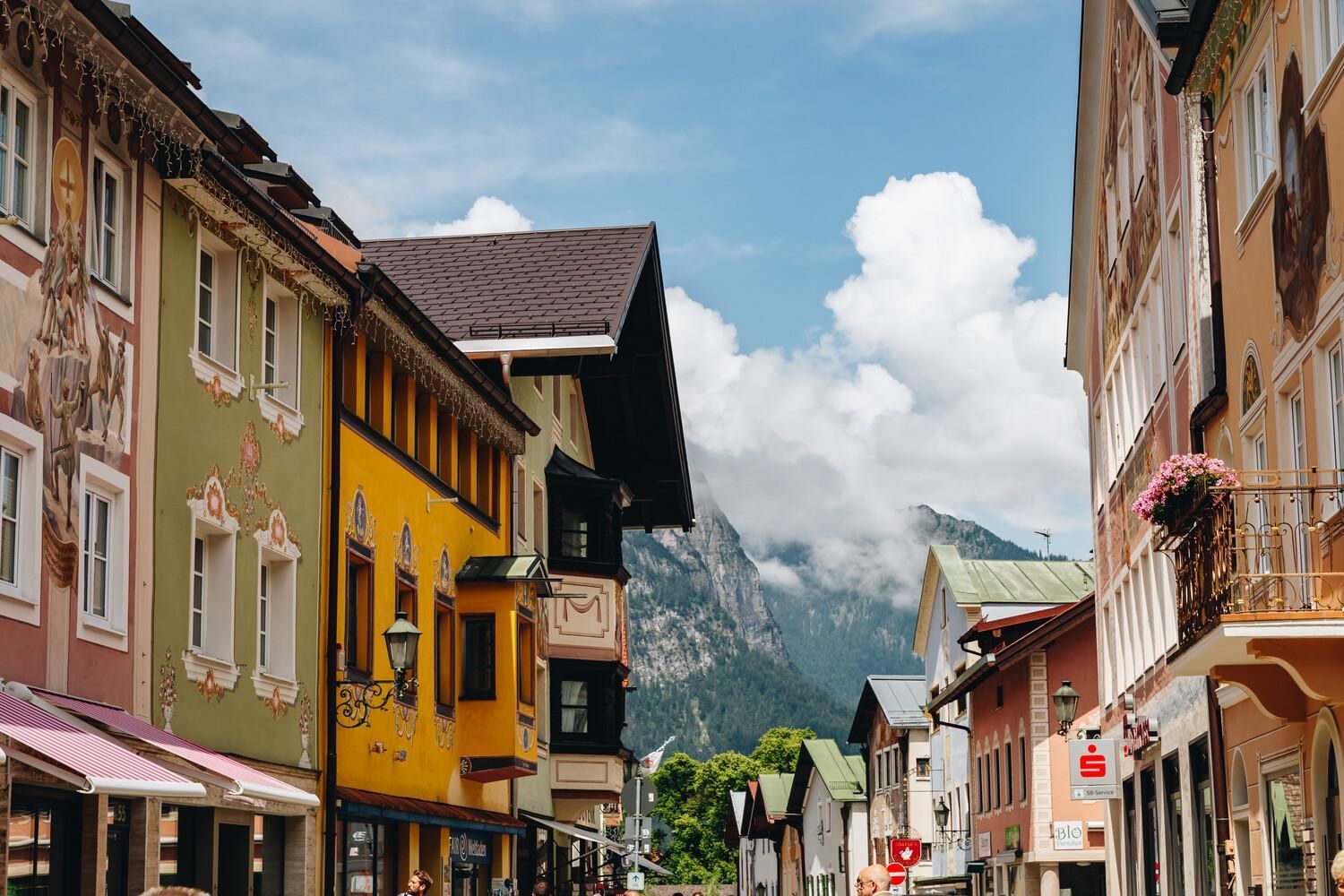 A street with colorful buildings, a mountain in the background, and a clear sky.
