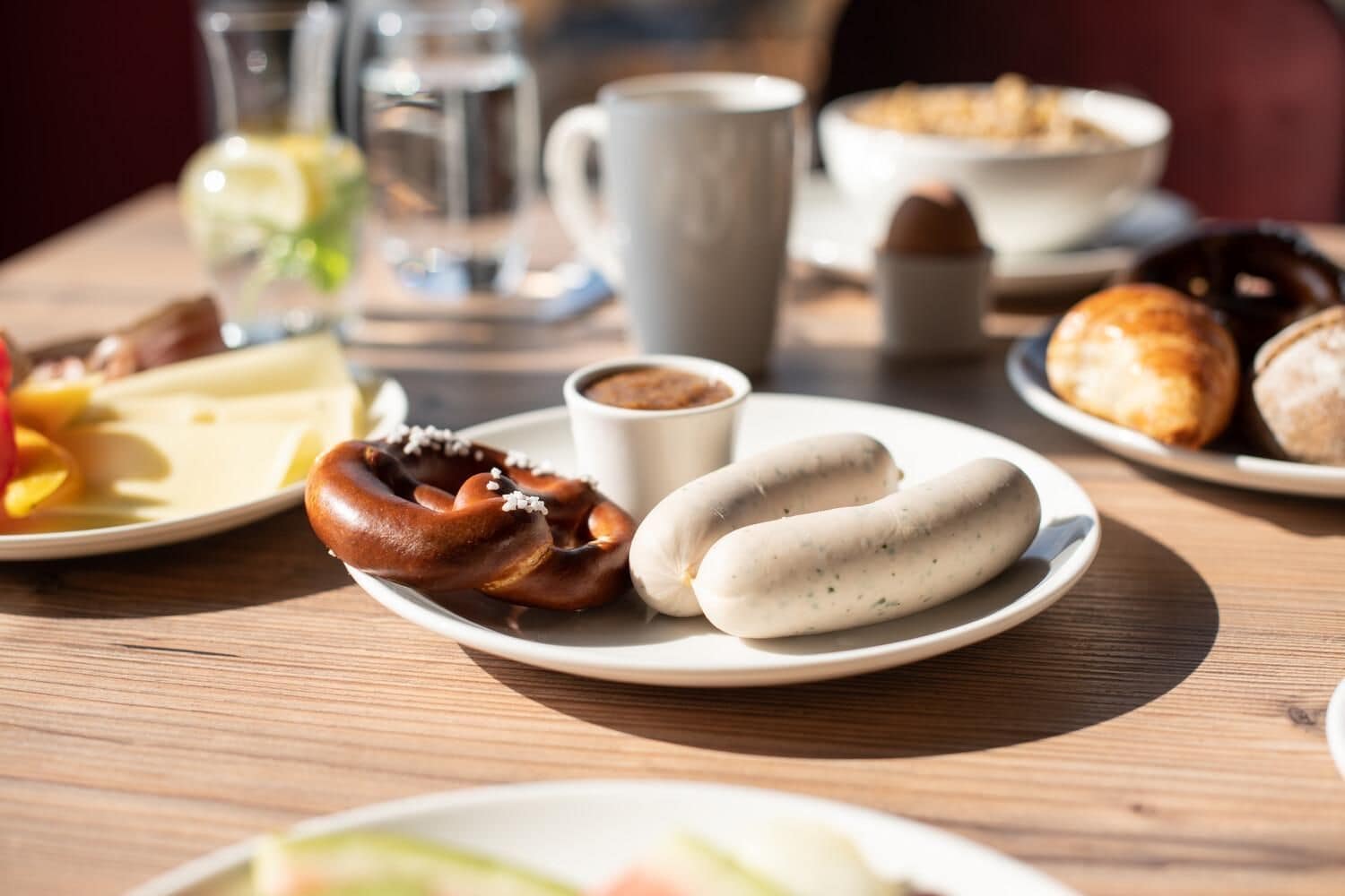 A breakfast setting with plates of food, a cup of coffee, and a glass of water.
