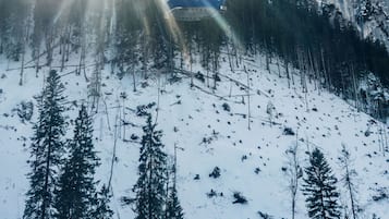 A cable car ascending a snowy mountain with a clear sky.