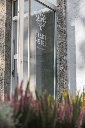 A glass door with the text "STADT HOTEL" and "OBERNBERG" on it. - Stadthotel Oberndorf - 24h Self Check-In Terminal  (Oberndorf bei Salzburg)