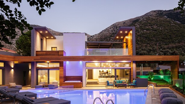 A modern two-story house with a swimming pool, outdoor seating, and a mountain backdrop. - Sauna, heated pool, kids pool, close to the beach & shops! (Rethymno)