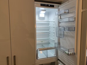 Kitchen features a modern refrigerator with digital display and ample storage.
