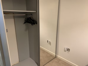 Guests can store their belongings in the closet with a hanging rod and ample space.