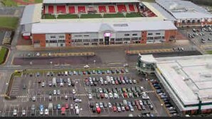 A large stadium with multiple seating tiers and a parking lot filled with cars. - Stylish and Immaculate 2-bed Apartment in Leigh (Leigh)