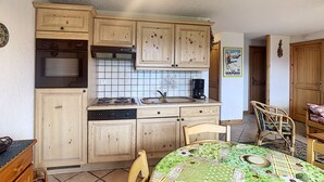 Eine kleine Küche mit Holzausstattung, einem Backofen und einer Kaffeemaschine.
