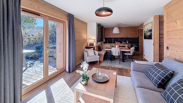 A modern living room with a sofa, a coffee table, and a dining area with chairs.